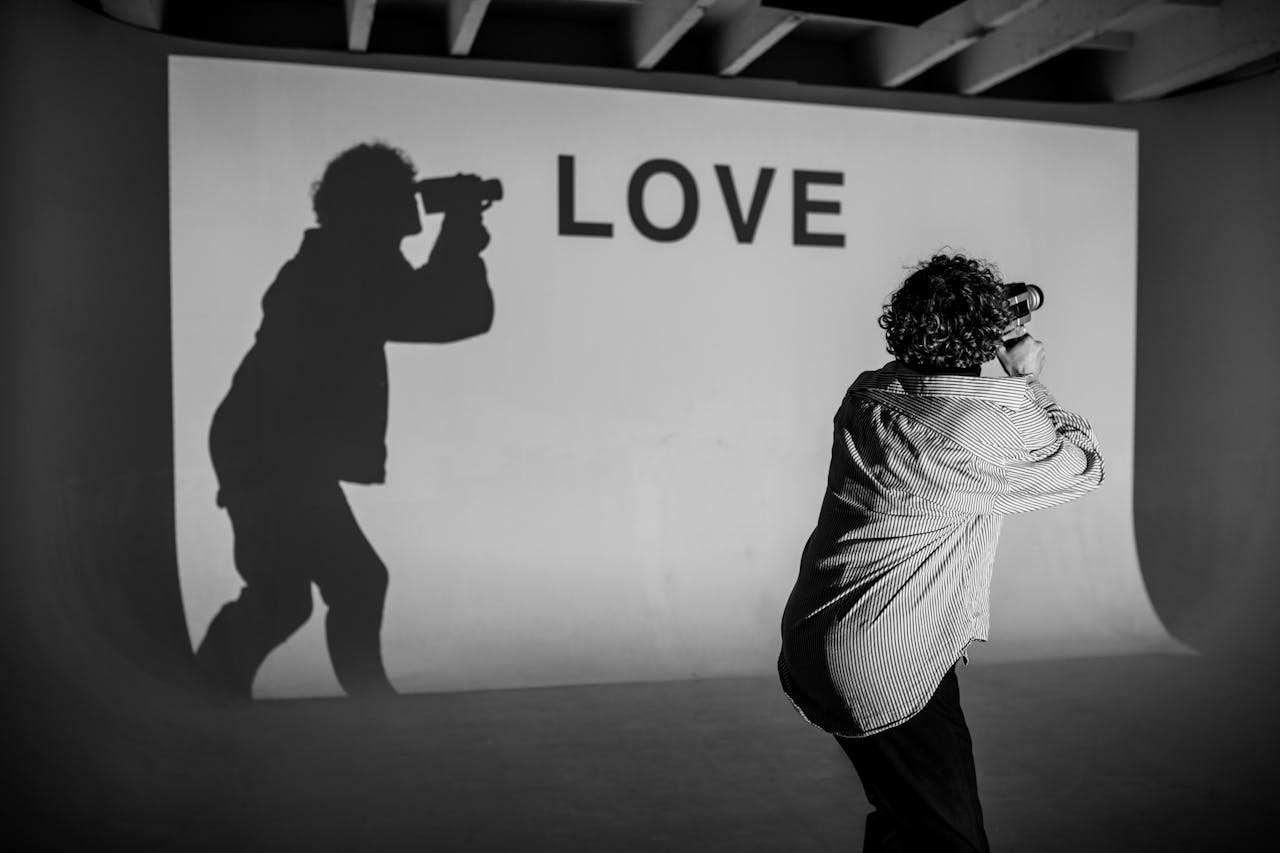 Man Holding A Camera With Shadow On Wall